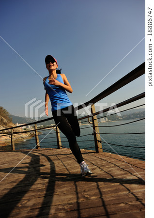 woman running on sunrise seaside boardwalk 18886747