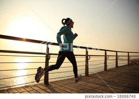 woman running on sunrise seaside boardwalk 18886748