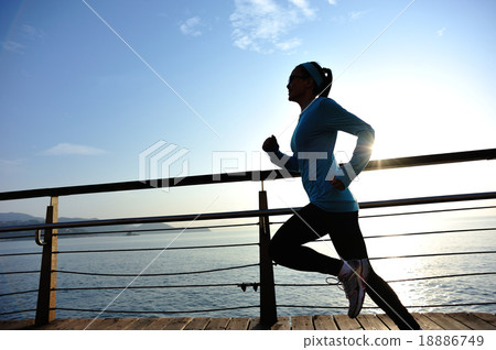 woman running on sunrise seaside boardwalk 18886749