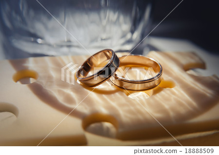 wedding rings lie on a cheese slice close up wedding rings lie on a cheese slice close up 18888509