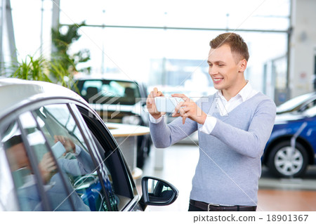 Pleasant man choosing car in auto show Pleasant man choosing car in auto show 18901367