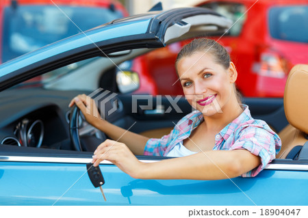 Young pretty woman sitting in a convertible car with the keys in 18904047