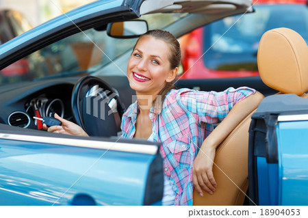 Young pretty woman sitting in a convertible car with the keys in Young pretty woman sitting in a convertible car with the keys in 18904053