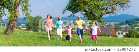 Father with children running on green meadow grass Father with children running on green meadow grass 18904278