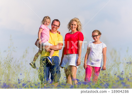 Family standing on meadow in summer with flowers Family standing on meadow in summer with flowers 18904286