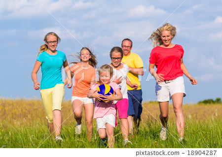 Family playing ball games on meadow Family playing ball games on meadow 18904287