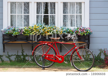 red bicycle in front of retro white window 18906608