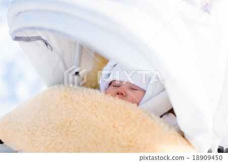 Newborn baby boy sleeping in stroller in winter 18909450