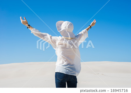 Woman lifting her hands up in the air Woman lifting her hands up in the air 18945716