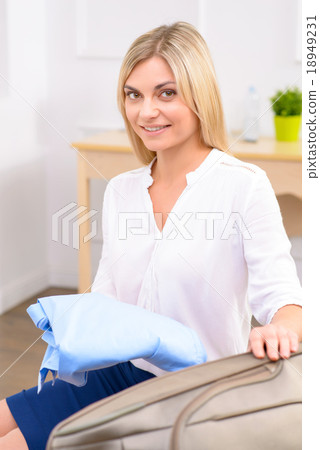 Young lady packing her baggage.  18949231