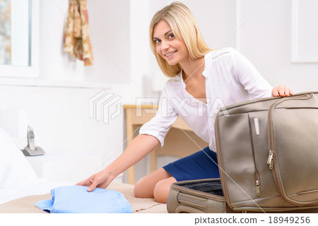 Attractive traveller unpacking her stuff. 18949256