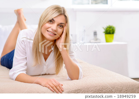 Young lady lying on hotel bed. 18949259