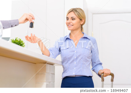 Young lady receiving her room key.  18949407