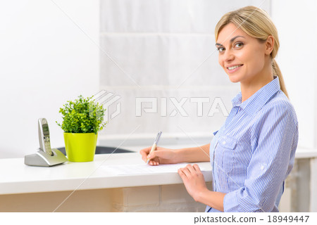 Young lady filling out hotel papers.  18949447