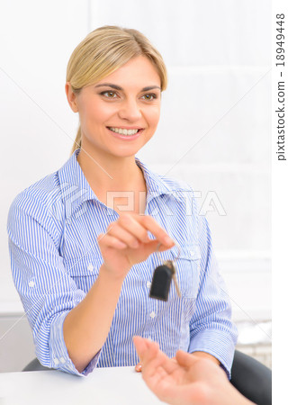 Attractive receptionist offering room key. 18949448