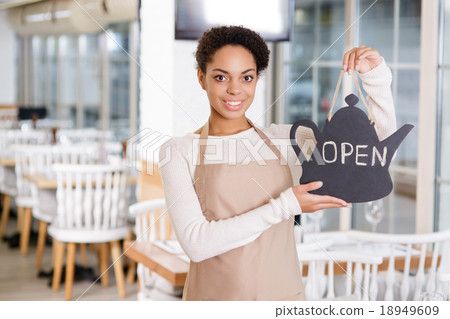 Smiling waitress holding an opening sign. Smiling waitress holding an opening sign. 18949609