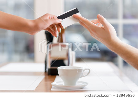 Waitress is taking credit card from a client. Waitress is taking credit card from a client. 18949656
