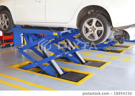 scissor cranes lift white car in garage 18954150