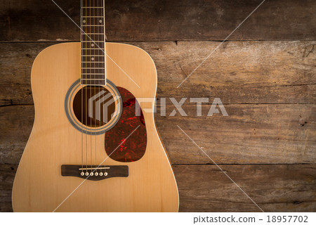 Top view of guitar on dark wood floor texture in 18957702