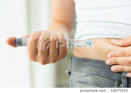 close up of hands making injection by insulin pen 18975955