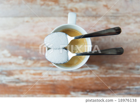 close up of white sugar on teaspoon and coffee cup close up of white sugar on teaspoon and coffee cup 18976138