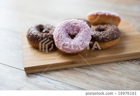 close up of glazed donuts pile on wooden table close up of glazed donuts pile on wooden table 18976181