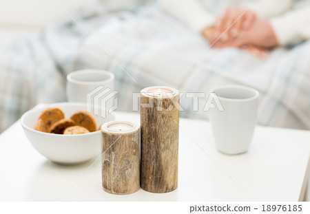 close up of candles, cookies and tea cups on table close up of candles, cookies and tea cups on table 18976185