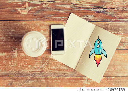 close up of notebook, coffee cup and smartphone close up of notebook, coffee cup and smartphone 18976189