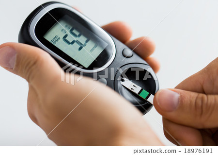 close up of man checking blood sugar by glucometer close up of man checking blood sugar by glucometer 18976191