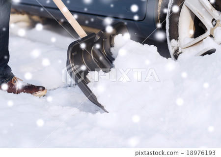 closeup of man digging snow with shovel near car closeup of man digging snow with shovel near car 18976193