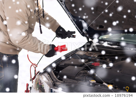 closeup of man under bonnet with starter cables closeup of man under bonnet with starter cables 18976194