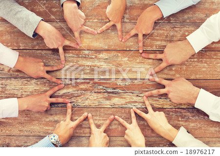 close up of business team showing victory gesture 18976217