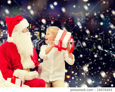 smiling little boy with santa claus and gifts smiling little boy with santa claus and gifts 18976883