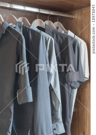 clothes hanging in wooden wardrobe 18978845
