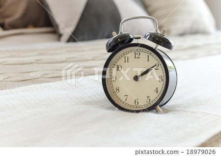 modern black alarm clock on bed 18979026