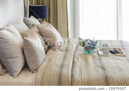 vase of flower with tray of cup and glasses on book in bedroom 18979167