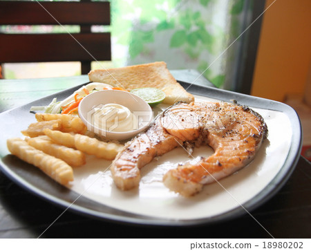 grilled salmon steak with french fries and toast. 18980202