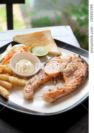 grilled salmon steak with french fries and toast. 18980399
