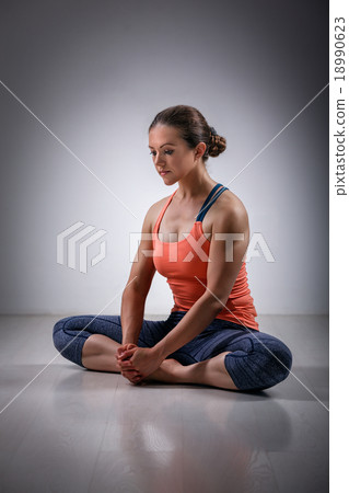 Woman practices yoga asana Baddha konasana 18990623