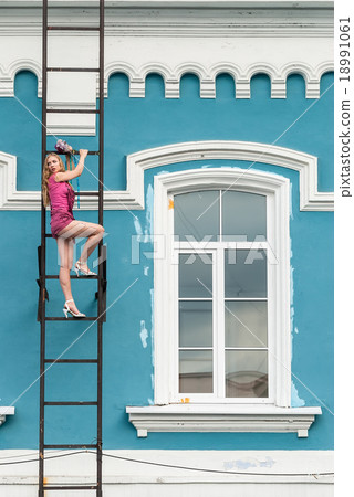 Pretty woman in pink on fire escape stair Pretty woman in pink on fire escape stair 18991061