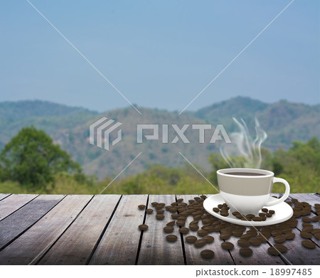 Cup with coffee on table over mountains landscape  18997485