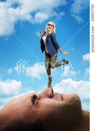 Woman standing on the man's face 18997706