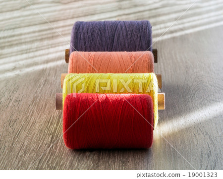 colored spools of thread for sewing, front view 19001323