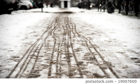 footprints on the snowy sidewalk 19007600