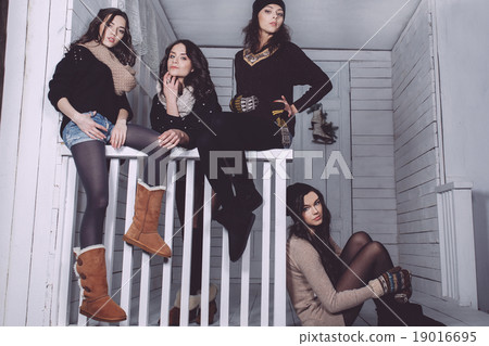 Four stylish models posing sitting on the fence 19016695
