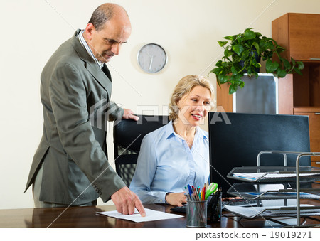 office scene with two elderly and serious workers 19019271