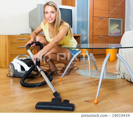 Woman cleaning with vacuum cleaner Woman cleaning with vacuum cleaner 19019434