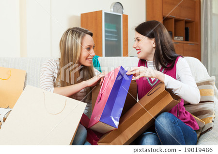 Smiling women looking shopping bags 19019486