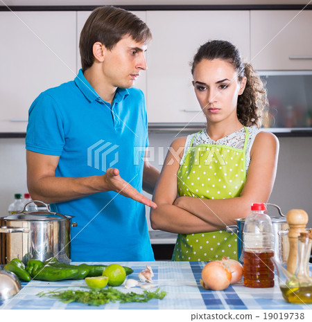family couple with serious faces quarrelling in kitchen 19019738