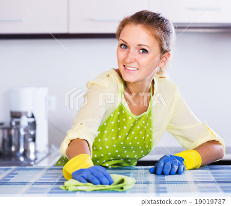 Woman dusting kitchen top at home Woman dusting kitchen top at home 19019787